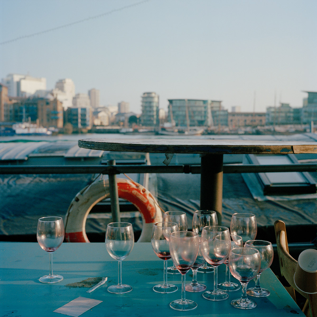 Des verres vide sur la table d'une barge accosté sur un mooring de la Tamise, Londres. Un lendemain de soirée.